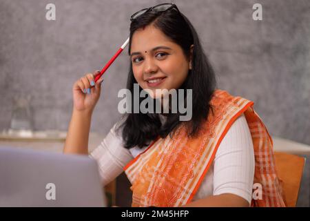 Ritratto di giovane donna che lavorano su computer portatile in ufficio Foto Stock