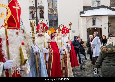 Altoetting, Germania-Dicembre 17,2022 : uomini vestiti come St Nicholas lascia la chiesa dopo una messa durante il tradizionale pellegrinaggio annuale. Foto Stock