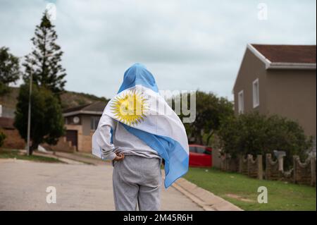 Persona avvolta in argentina bandiera sparata da dietro Foto Stock