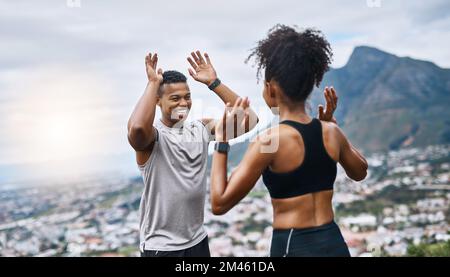 Erano la squadra vincente. una giovane coppia sportiva che si five l'un l'altro mentre si esercita all'aperto. Foto Stock