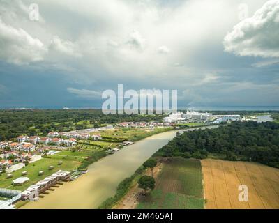 Terreno agricolo, hotel e campi da golf vicino al fiume che scorre verso il mare Foto Stock
