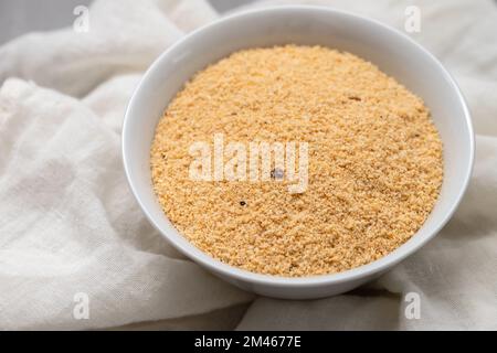 Farofa, tipico contorno di farina di manioca brasiliana su ceramica grigia Foto Stock