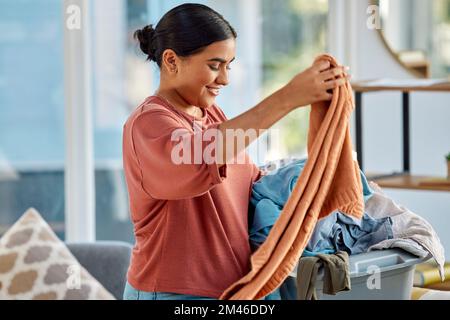 Pulizia, cesto di lavanderia e donna con vestiti a casa pronti a lavare i vestiti. Pulizia primaverile, igiene e felice femmina preparazione per il tessuto Foto Stock