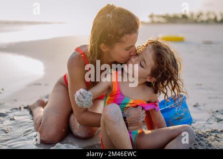Madre con la figlia che si gode del tempo in mare. Foto Stock