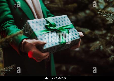 Primo piano della donna in possesso di regali, all'aperto al mercato di Natale. Foto Stock