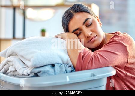 Donna, cesto di bucato e dormire mentre stanco, rilassarsi o riposare nel soggiorno dopo la pulizia, lavaggio e imballaggio. Casalinga, più pulita e dove dormire Foto Stock