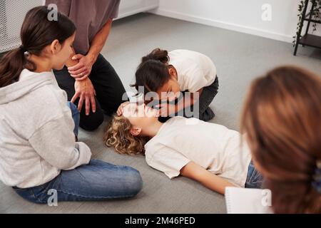 Insegnanti che offrono formazione di pronto soccorso Foto Stock