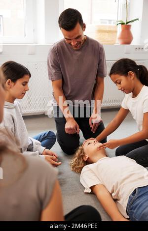 Insegnanti che offrono formazione di pronto soccorso Foto Stock