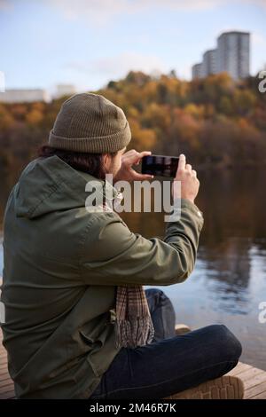 Uomo di scattare una foto con il telefono cellulare Foto Stock