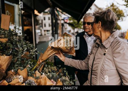 Coppia anziana che sceglie il bouquet nel negozio di fiori Foto Stock