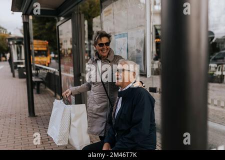 Coppia anziana in attesa alla fermata dell'autobus Foto Stock