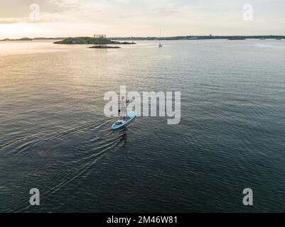 Donna paddleboarding in mare Foto Stock