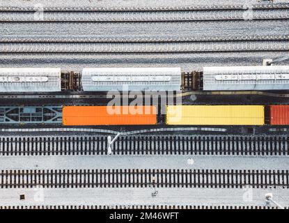 Vista dall'alto verso il basso carri colorati in piedi ancora parcheggiati sulle linee ferroviarie Foto Stock