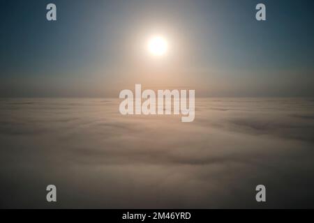 Vista aerea dall'alto ad alta quota di dense nuvole di cumulo puffy volare in serata. Incredibile tramonto dal punto di vista della finestra dell'aeroplano Foto Stock