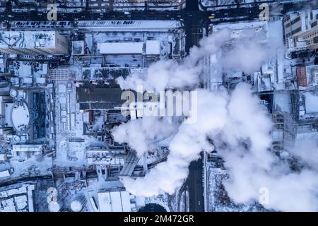 Dal tubo della caldaia fuoriesce del fumo. Riscaldamento centralizzato degli edifici. Tramonto invernale Foto Stock