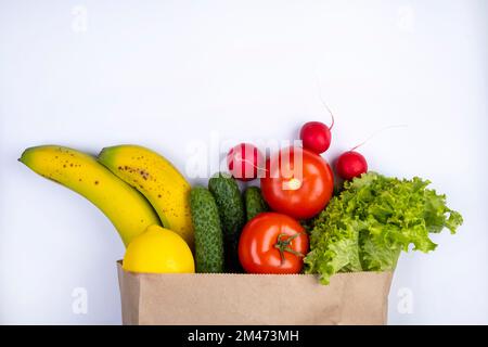 sacchetto di carta con prodotti, verdure e frutta su sfondo bianco. Foto di alta qualità Foto Stock