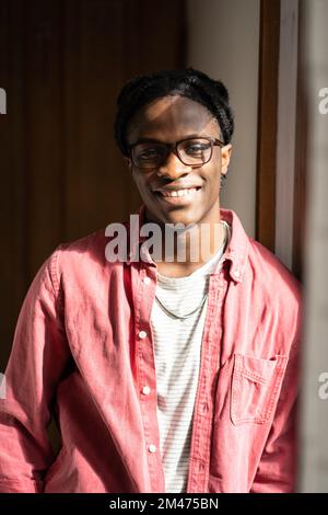 Felice ottimista giovane afroamericano ragazzo in piedi a casa esprimere emozioni positive Foto Stock