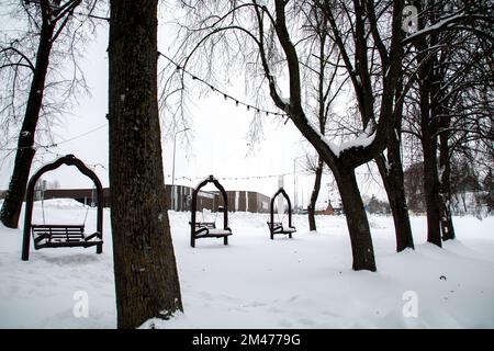 foto swing in forma di panchine con le spalle in inverno coperte di neve Foto Stock