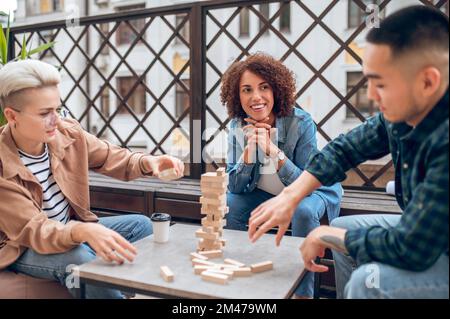 Giovani che giocano a una partita da tavolo durante la pausa caffè Foto Stock