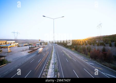 Traffico stradale al tramonto. Esposizione lunga Foto Stock