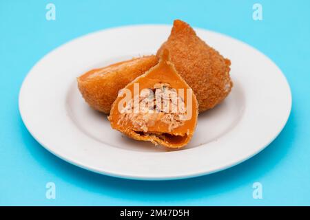 I tradizionali drumsticks brasiliani fritti Coxinha de frango su un piatto piccolo Foto Stock