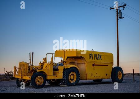 Trattore giallo che trasporta un rimorchio con un serbatoio di propano. Caterpillar serie DX10 1N 4x2. Viene abbandonato Foto Stock