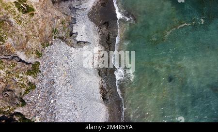 Bellissima spiaggia rocciosa sulla costa meridionale dell'Irlanda vicino a Clonakilty. La pittoresca costa del Mar Celtico. Surf in mare. Acque turchesi dell'Atlante Foto Stock