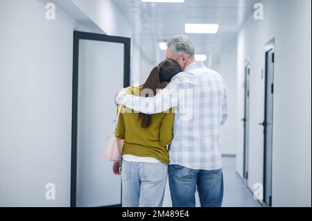 Una coppia nel corridoio clinico dopo la procedura diagnostica Foto Stock