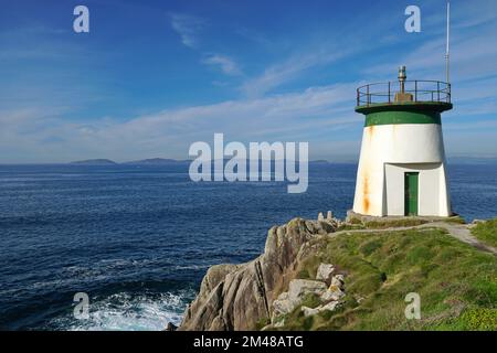 Faro sulla costa della Galizia in Spagna con l'isola di Ons all'orizzonte, provincia di Pontevedra, Cangas, oceano Atlantico Foto Stock