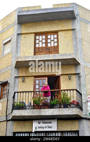 Donna in piedi sul balcone di appartamenti, appartamenti, sopra ristorante nel villaggio di San Bartolomé de Tirajana, Gran Canaria Foto Stock