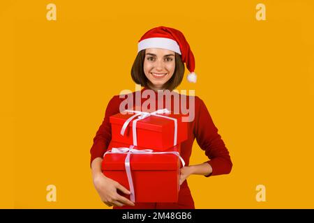 Felice giovane donna eccitata in cappello di santa con le scatole del regalo Foto Stock