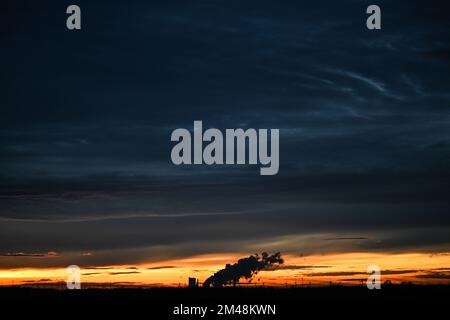 19 dicembre 2022, Renania settentrionale-Vestfalia, Niederaußem: Il sole è tramontato dietro la centrale a lignite di Niederaussem. Foto: Federico Gambarini/dpa Foto Stock