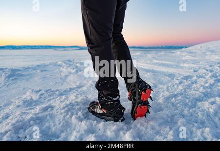 Mountain Boot con ramponi durante le escursioni in montagna in inverno. Foto Stock