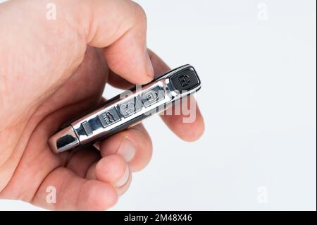 Tasti di controllo sulla chiave dell'auto sulla mano umana vista ravvicinata isolata Foto Stock