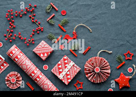 Beato Yule, Natale, Festival invernale lettone. Simboli etnografici, modelli dalla Lettonia. Amuleti in legno, carta da imballaggio, scatole regalo con rametti in abete Foto Stock