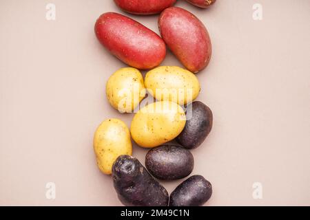 Diversi tipi di patate su sfondo colorato Foto Stock