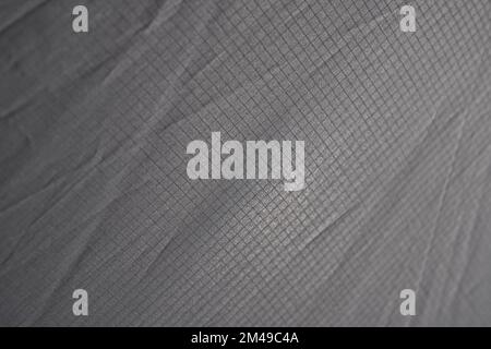 Mesh desaturata astratta sfuma grigio chiaro struttura del materiale per lo sfondo. Primo piano di tessuto a plaid grigio pallido, leggero e senza cuciture, con motivo diagonale. Concetto di texture di sfondo. Foto Stock