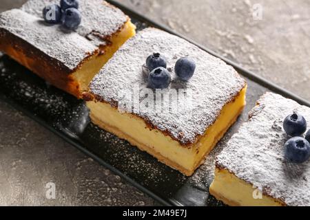 Torta al formaggio con mirtilli su un tavolo di grunge scuro Foto Stock