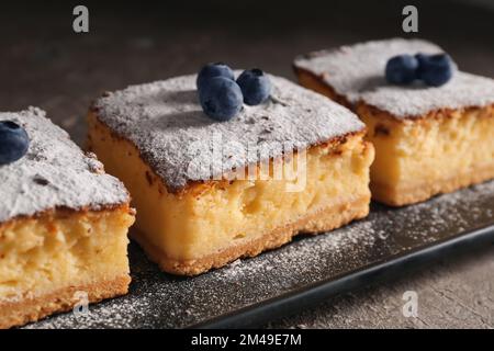 Torta al formaggio con mirtilli su un tavolo di grunge scuro Foto Stock