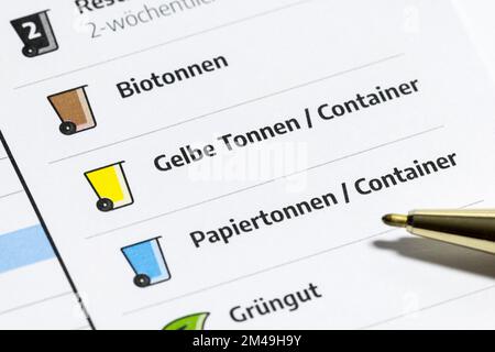 Calendario annuale per lo smaltimento dei rifiuti, contenitori gialli, contenitori per rifiuti organici, carta, rifiuti verdi, date del prelievo, penne a sfera Foto Stock