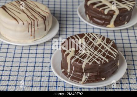 Tre alfajores, caramelle tipiche dell'Argentina, su una tovaglia a scacchi. Foto Stock