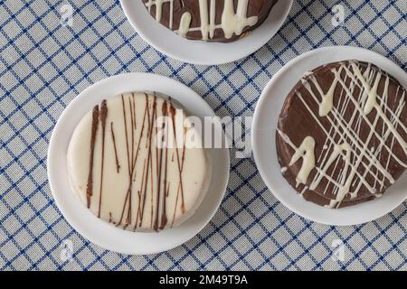 Vista dall'alto di alfajores, caramelle tipiche dell'Argentina, su una tovaglia a scacchi. Foto Stock