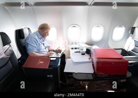 PA RECENSIONE DELL'ANNO 2022 Foto del file datata 17/03/22 - il primo ministro Boris Johnson lavora a bordo del suo aereo mentre ritorna dall'Arabia Saudita dopo aver trascorso una giornata negli Emirati Arabi Uniti e in Arabia Saudita per rafforzare i legami con le nazioni del Golfo. Data di emissione: Martedì 20 dicembre 2022. Foto Stock