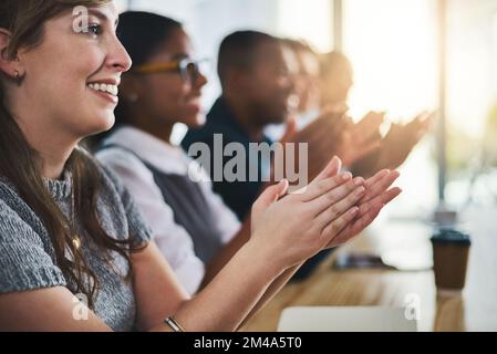 Un gruppo di giovani uomini d'affari che plauda mentre siede in sala conferenze durante un seminario merita un plauso. Foto Stock