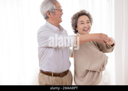 Allegro coppia cinese anziana ballare a casa Foto Stock