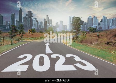 Concetto di nuovo anno 2023. Testo 2022 scritto sulla strada nel mezzo della strada al tramonto. Inizio anno nuovo Foto Stock
