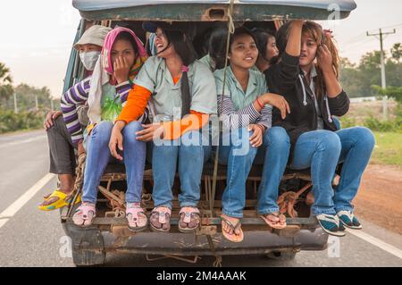 Donne cambogiane, lavoratori di abbigliamento, imballati nella parte posteriore di un furgone che indossa jeans blu denim e infradito. Provincia di Kampong Speu, Cambogia. © Kraig Lieb Foto Stock