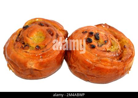 Rotolo di spugnetta alla cannella addolcito con miele e uvetta e ripieno di crema pasticcera al forno, focus selettivo di pasticceria panetteria croissant dan arrotolato Foto Stock