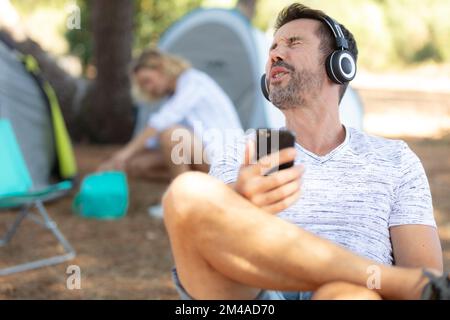 giovani che ascoltano un giocatore di mp3 in un campeggio Foto Stock