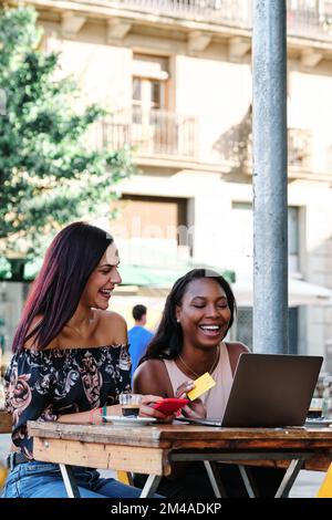 Amici che fanno un certo shopping in linea in una caffetteria Foto Stock